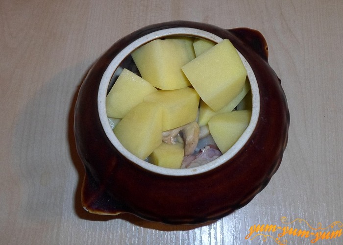 Перекласти підготовлену картоплю в горщик, залити водою і поставити в духовку